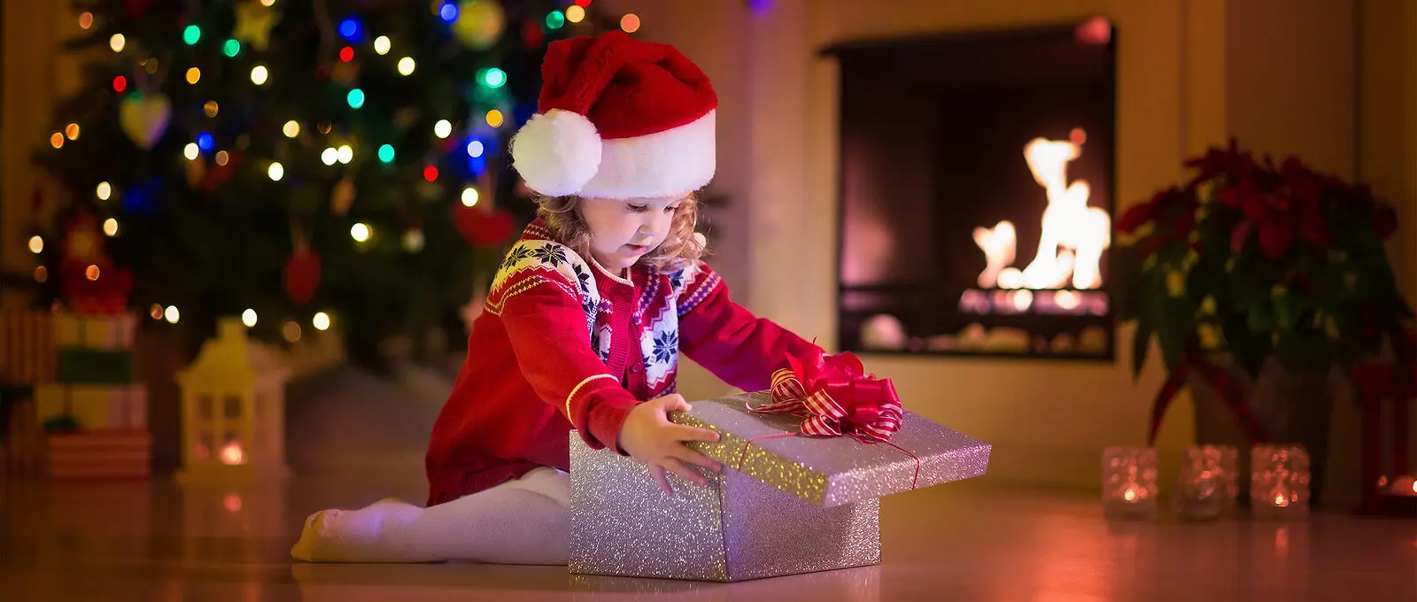 Kids Opening Christmas Presents At Fireplace
